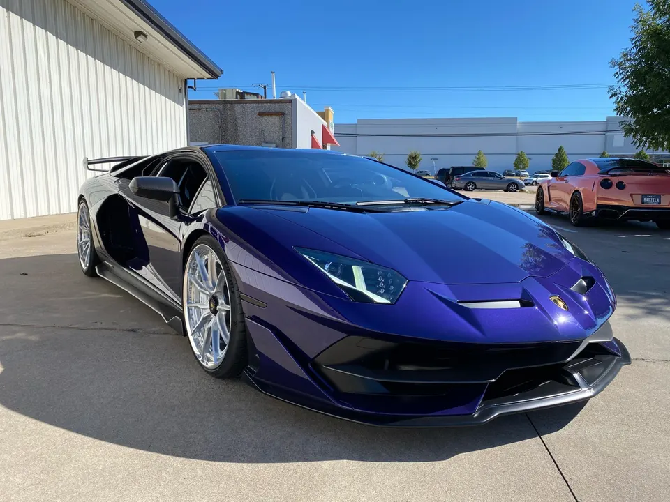 Purple Lamborghini Aventador with custom wheels and aero kit parked outside Jotech Motorsports.