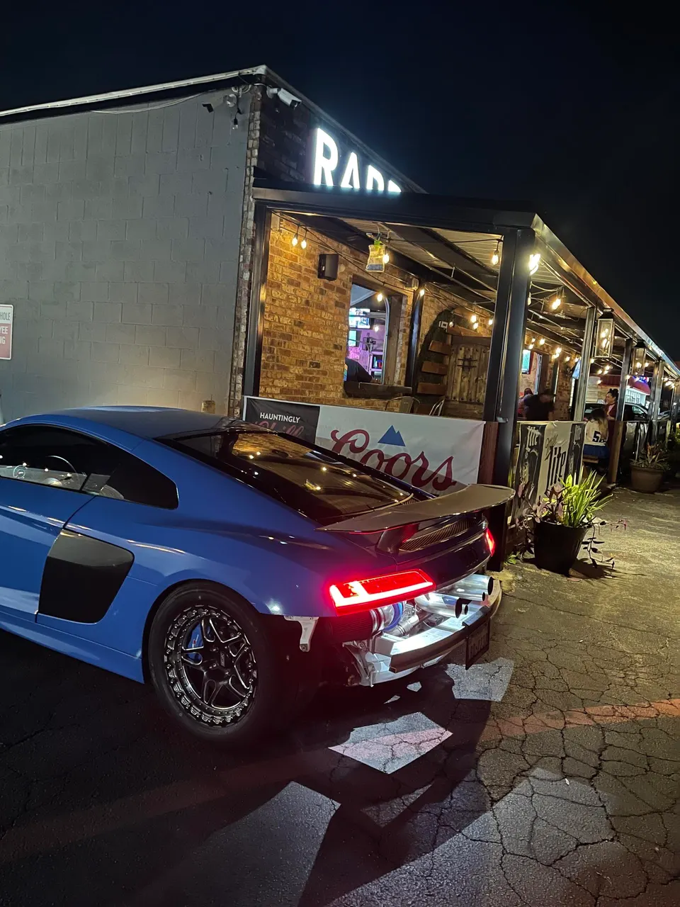 Blue Audi R8 with exposed rear showing custom turbo system and exhaust, highlighting performance modifications.
