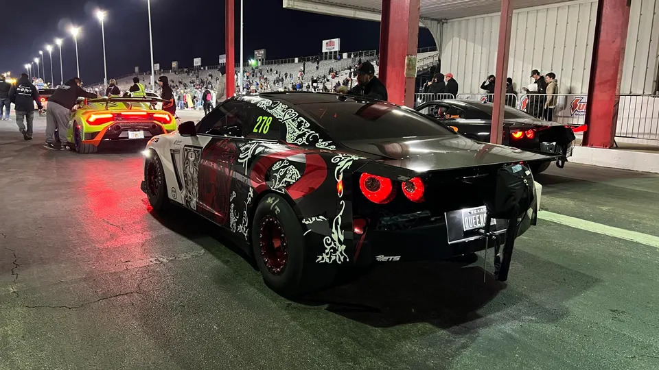 A highly modified Nissan GT-R and a Lamborghini Huracan in the staging lane at a night drag race event.