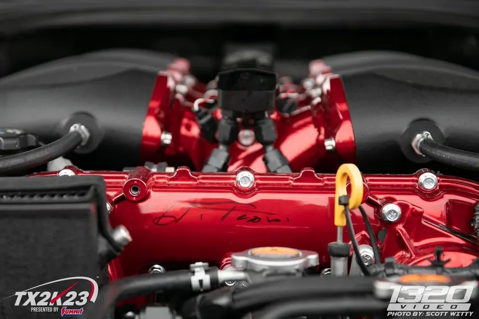 Close-up of a custom red intake manifold and valve covers in a high-performance engine bay.