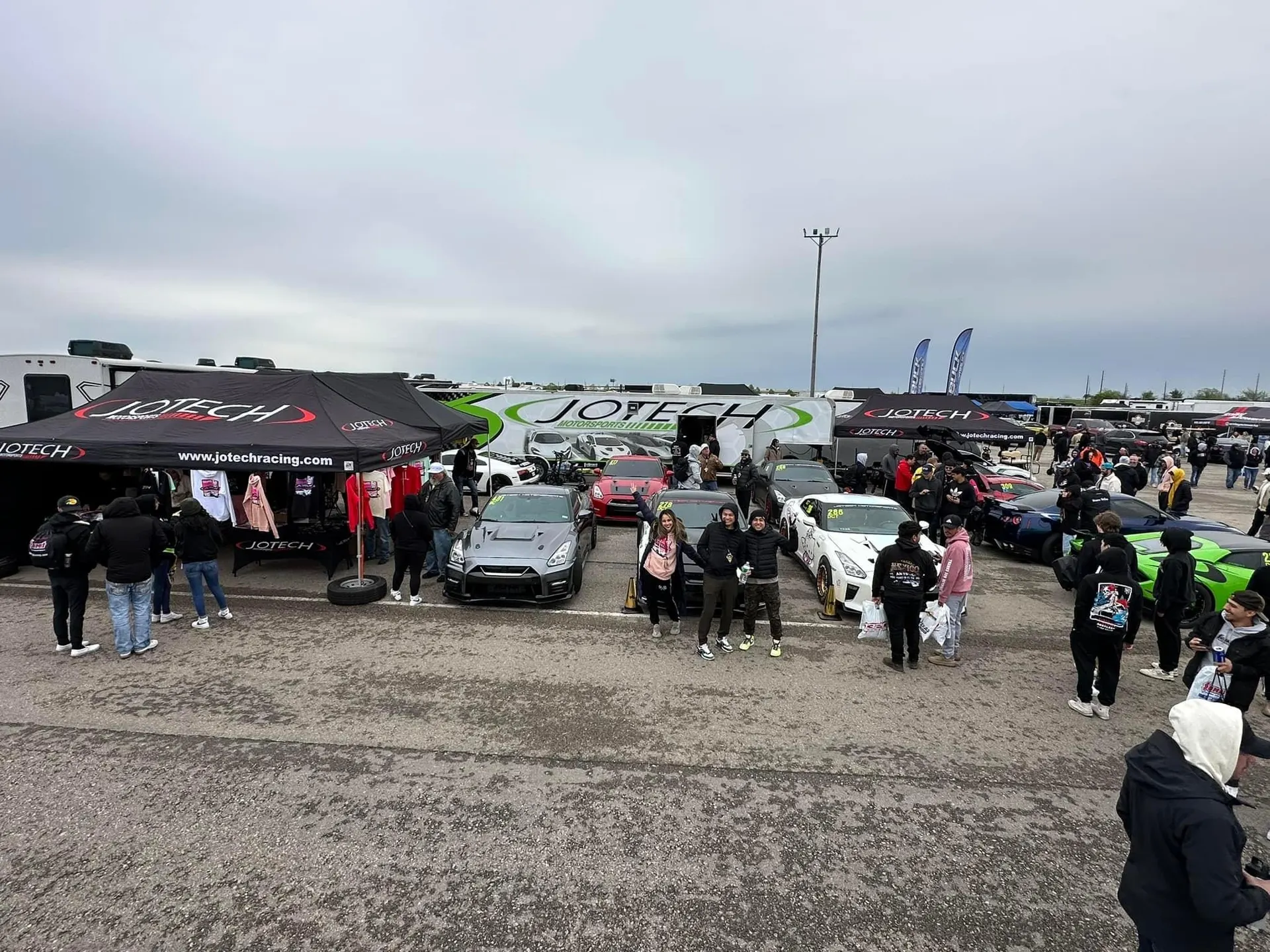 Jotech Racing booth at a car event with multiple modified Nissan GT-Rs and Lamborghinis on display