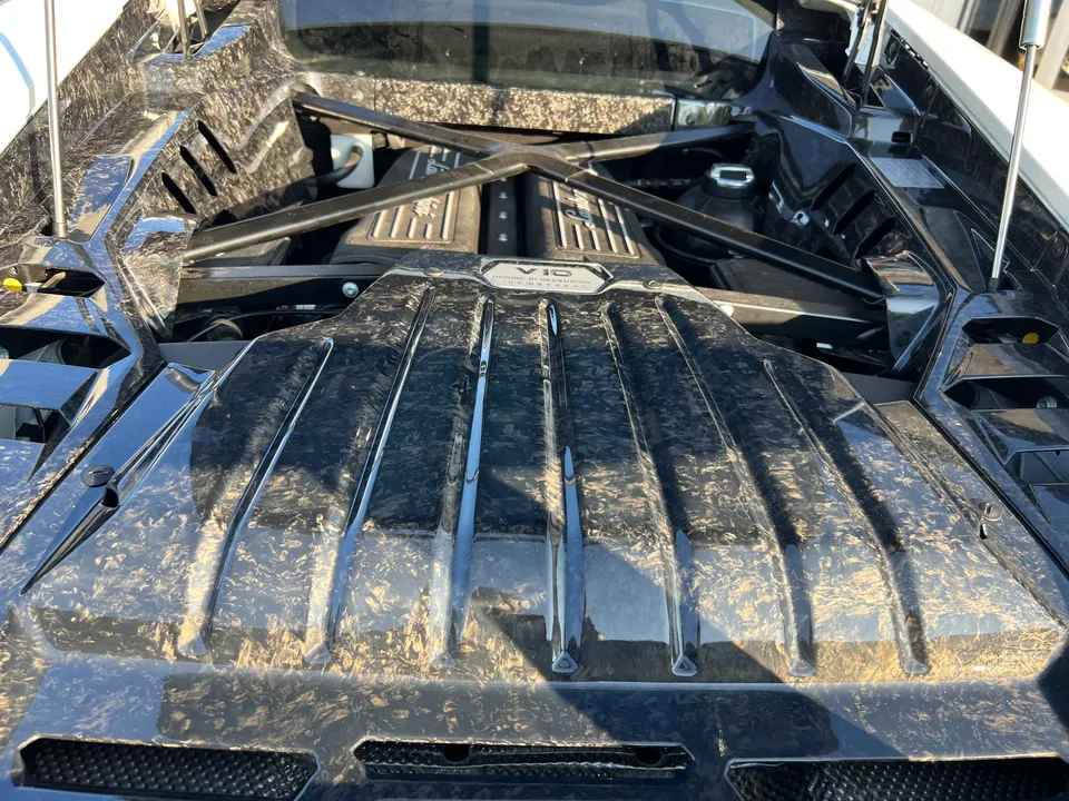 Close-up of a Lamborghini Huracan V10 engine bay with forged carbon fiber engine cover