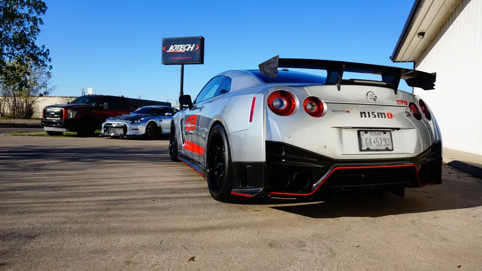 Silver Nissan GT-R Nismo with a large rear wing and aggressive diffuser parked outside Jotech Motorsports.
