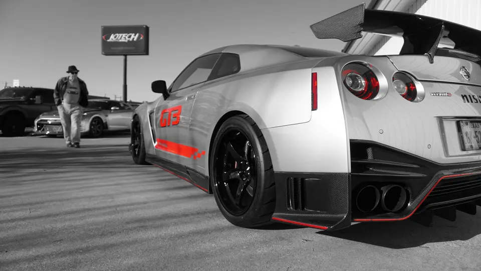 Silver Nissan GT-R R35 with red GT3 decals, carbon fiber aero, aftermarket wheels, and custom exhaust parked at Jotech Motorsports.