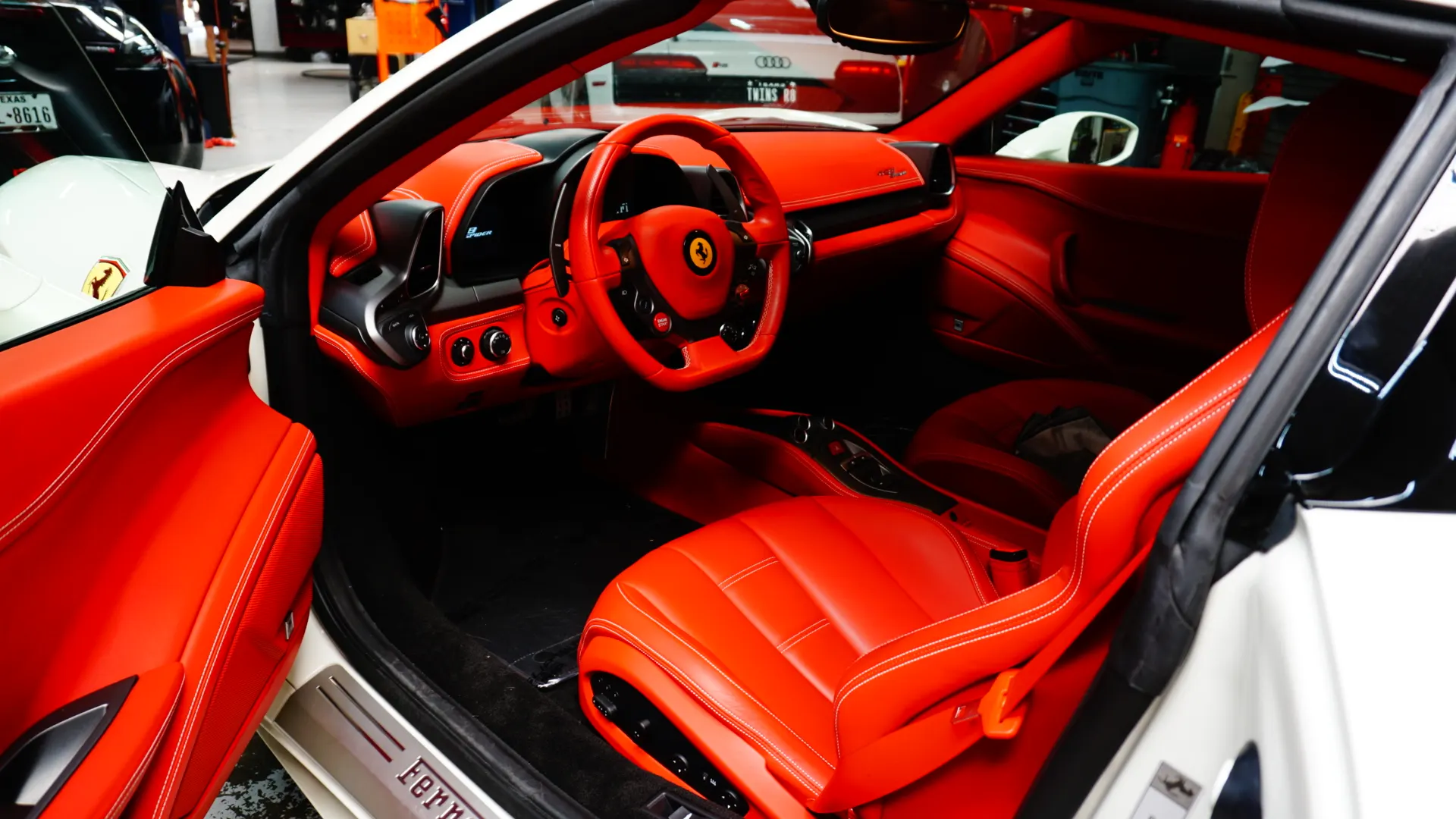 Detailed view of the vibrant red leather interior of a Ferrari, highlighting the steering wheel, seats, and dashboard.