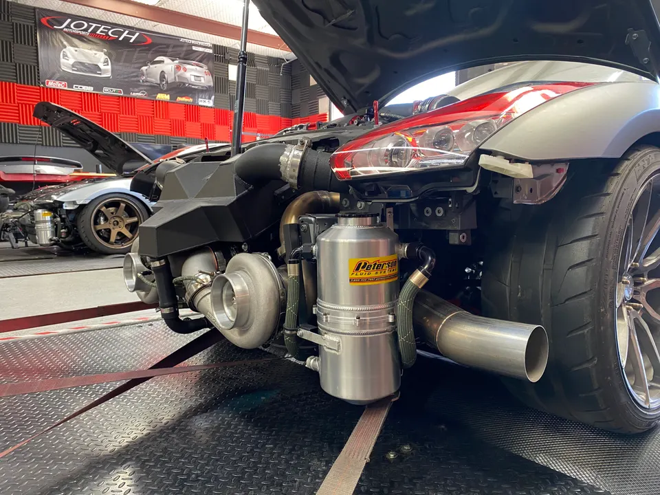 Nissan GT-R on a dyno with exposed twin turbochargers and custom exhaust system at Jotech Motorsports