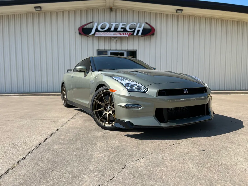 Custom light green Nissan GT-R R35 parked outside Jotech Motorsports, showcasing its aftermarket wheels and sleek design.