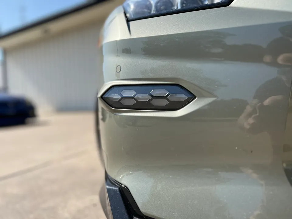 A close-up of a car's front bumper featuring an integrated LED daytime running light.