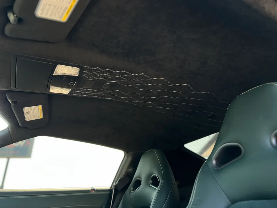 Custom black alcantara headliner with diamond stitching and overhead console in a performance car interior.