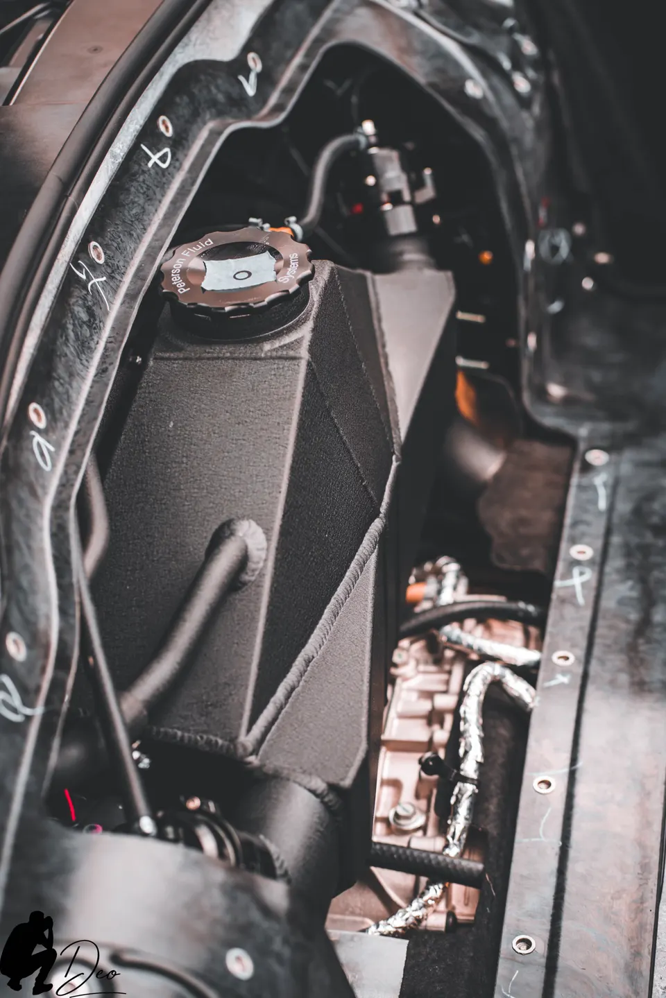 Close-up view of a custom fluid reservoir with a Peterson Fluid Systems cap in a high-performance car's engine bay.