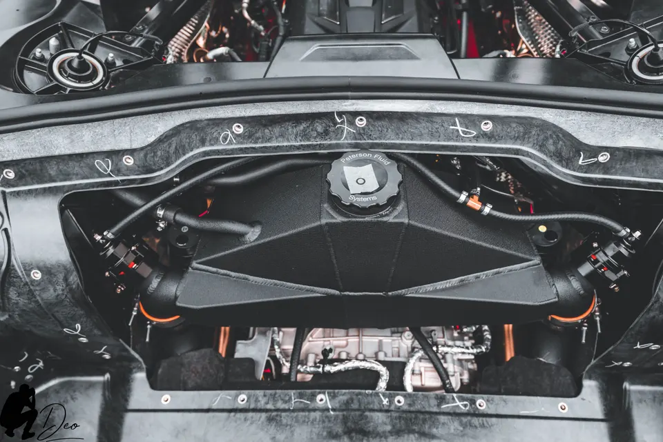Detailed view of a high-performance engine bay showcasing a Peterson Fluid Systems reservoir and custom fluid lines.