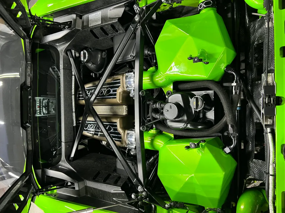 Overhead view of a custom green and gold engine bay in a Lamborghini Huracan, featuring Jotech performance parts.
