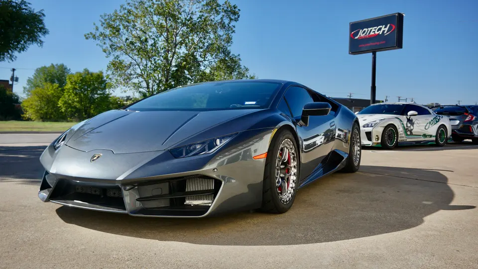 Grey Lamborghini Huracan with aftermarket drag wheels and visible intercooler parked outside Jotech Motorsports.