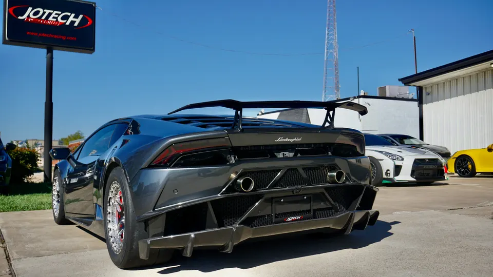 A modified Lamborghini Huracan with a large rear wing and diffuser parked outside Jotech Motorsports.