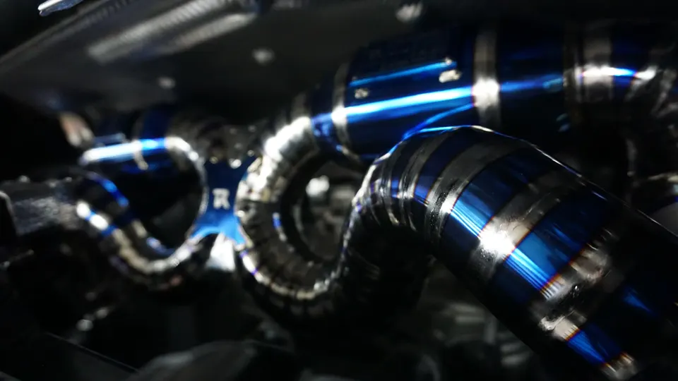 Close-up of a Jotech Motorsports custom titanium exhaust system with blue burnt finish.