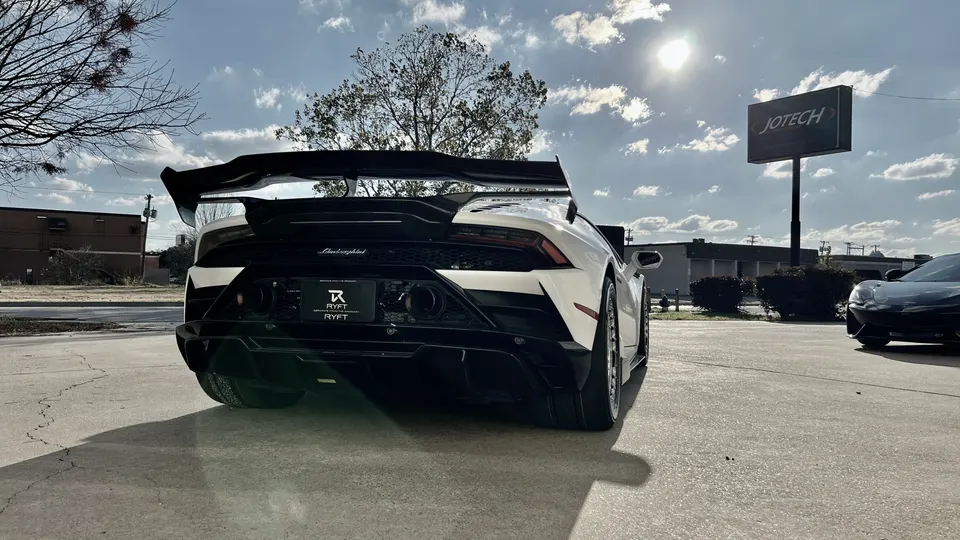 White Lamborghini Huracan with a large aftermarket rear wing and diffuser parked outside Jotech Motorsports.