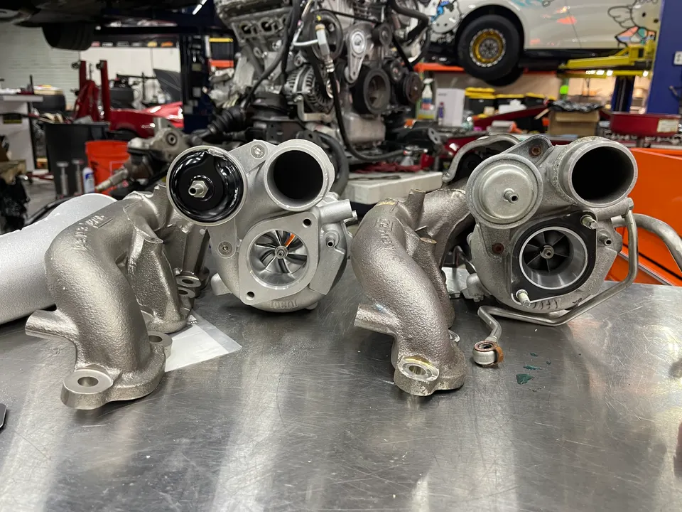 New and old turbochargers on a workbench in a performance tuning shop, ready for an engine upgrade.