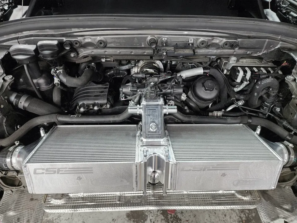 Close-up of a CSF intercooler installed in a performance car's engine bay, showcasing the upgraded cooling system.