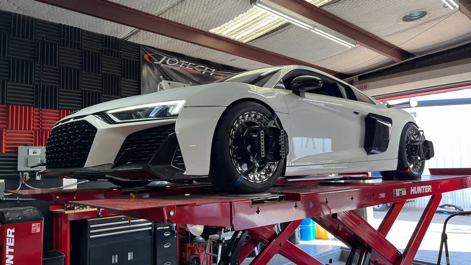 White Audi R8 supercar on a red Hunter alignment rack at Jotech Motorsports performance tuning shop