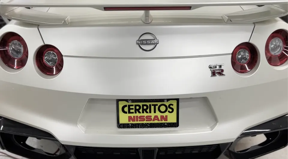 Rear view of a white Nissan GT-R showcasing its iconic taillights, spoiler, and bumper design.