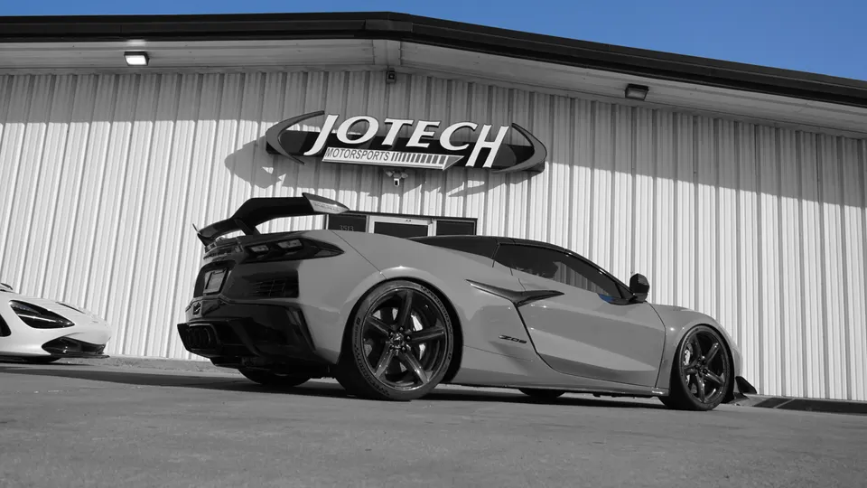 Grey Chevrolet Corvette C8 Z06 with aftermarket wheels and rear wing parked outside Jotech Motorsports.