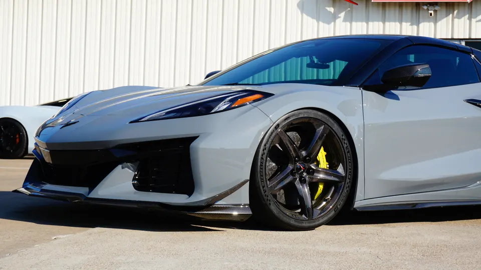 A grey Chevrolet Corvette C8 with carbon fiber wheels, yellow brake calipers, and a carbon fiber front splitter.