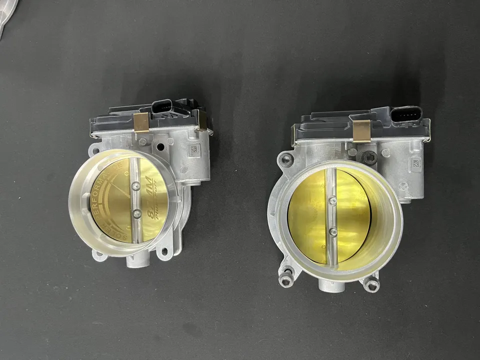 Two Soler Performance 87mm throttle bodies on a dark background, showcasing performance induction parts.