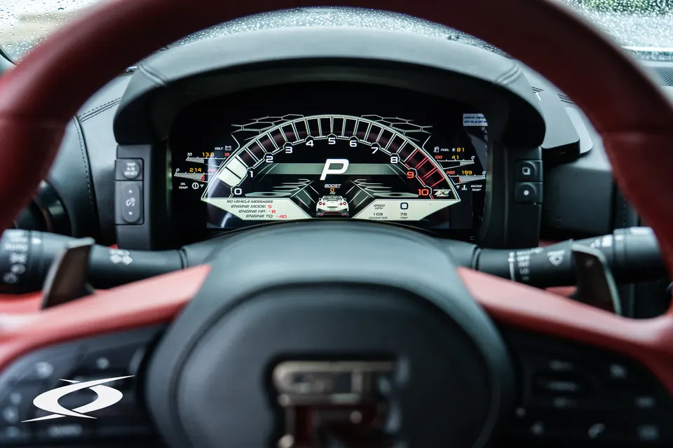 Nissan GT-R interior showing the digital dashboard and red leather steering wheel