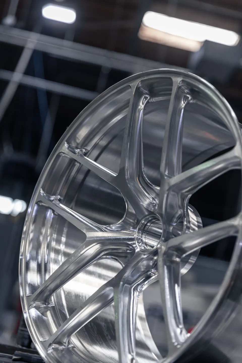 A close-up of a polished silver multi-spoke performance wheel, showcasing its intricate design and finish.