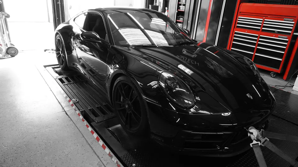 Black Porsche 911 strapped to a dynamometer for performance testing at Jotech Motorsports