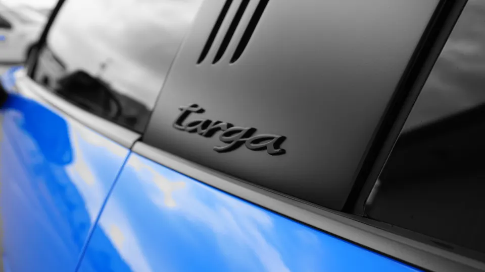 Close-up of the 'targa' script and vents on the C-pillar of a blue Porsche 911 Targa.