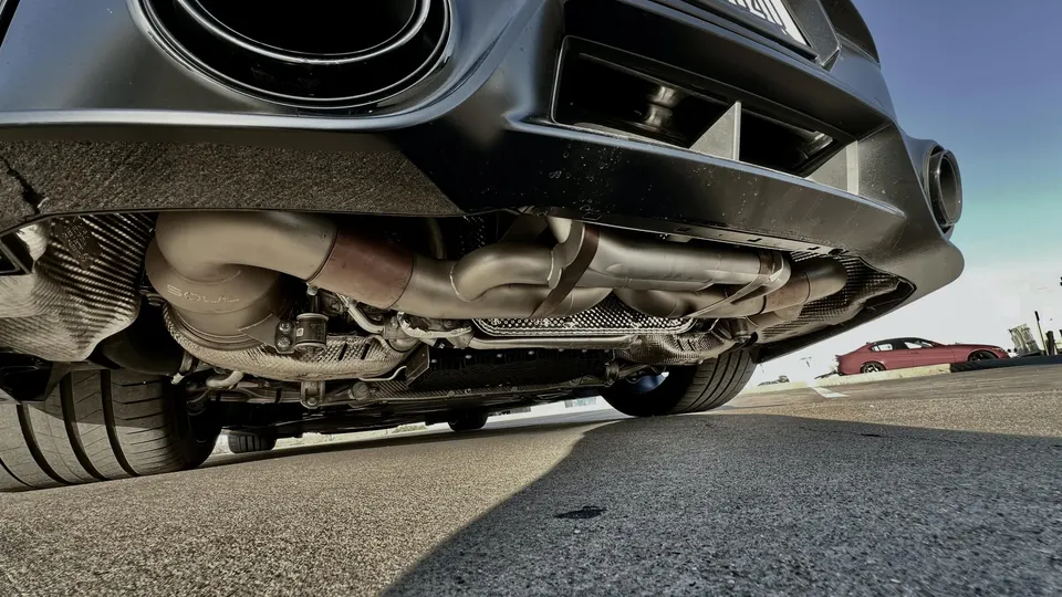 A low-angle detail shot of a Porsche's aftermarket exhaust system, featuring Soul Performance components.