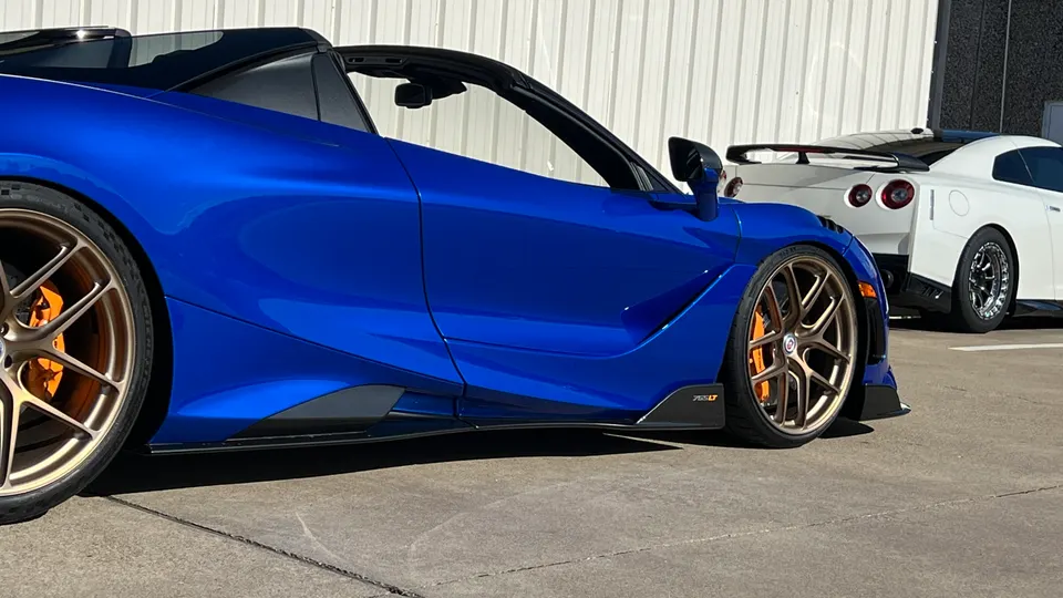 Blue McLaren 765LT with bronze HRE wheels and orange calipers parked next to a white Nissan GT-R.