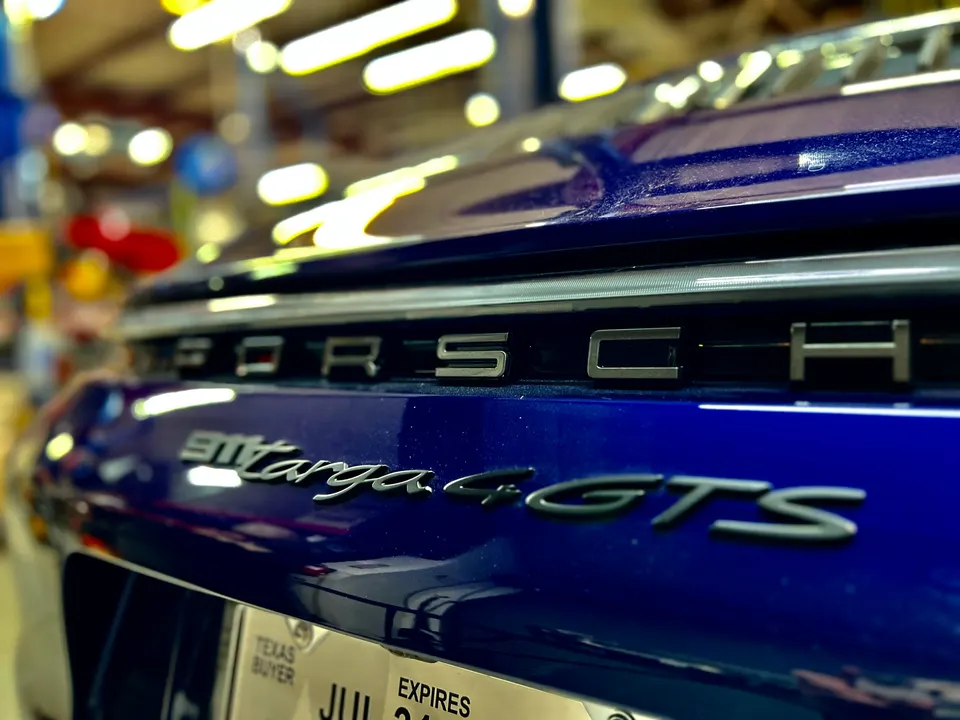 Close-up of the rear badging on a blue Porsche 911 Targa 4 GTS, showing the model name and Porsche script.
