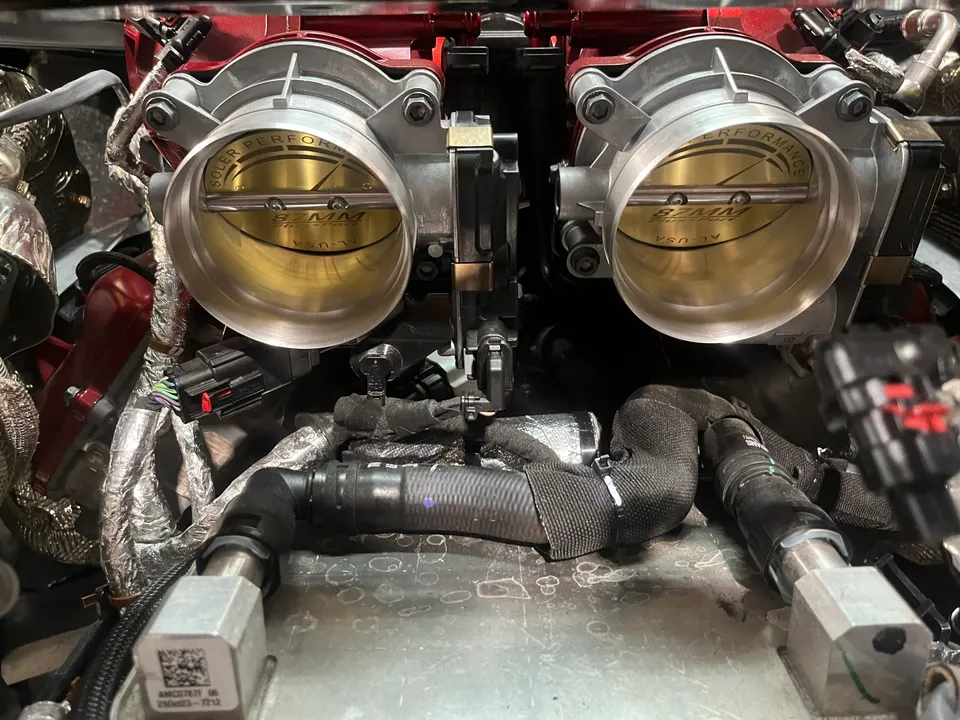 Close-up of a performance engine bay featuring Soler Performance 87mm throttle bodies and an aftermarket intake manifold.