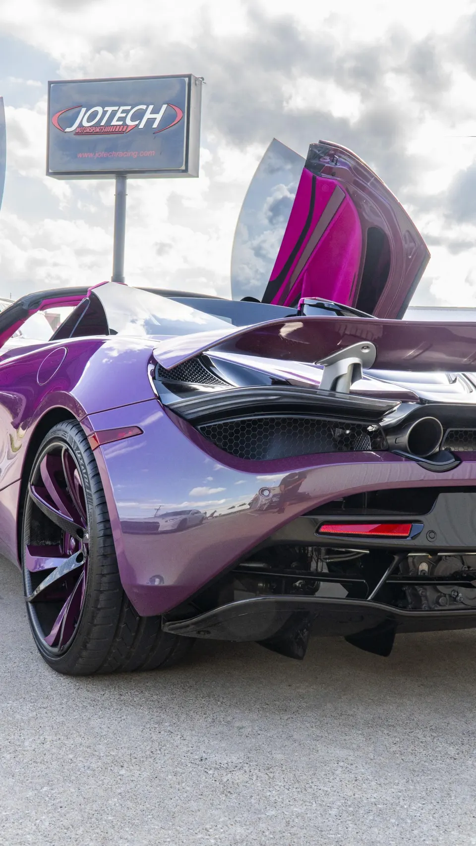 Purple McLaren 720S with butterfly door open, showcasing its rear wing and diffuser at Jotech Motorsports.