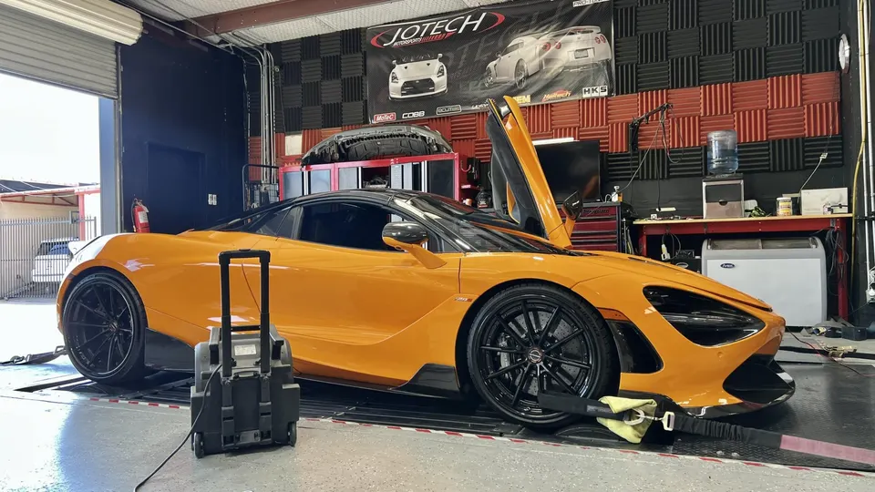 Orange McLaren 720S supercar strapped to a dynamometer for performance tuning at Jotech Motorsports