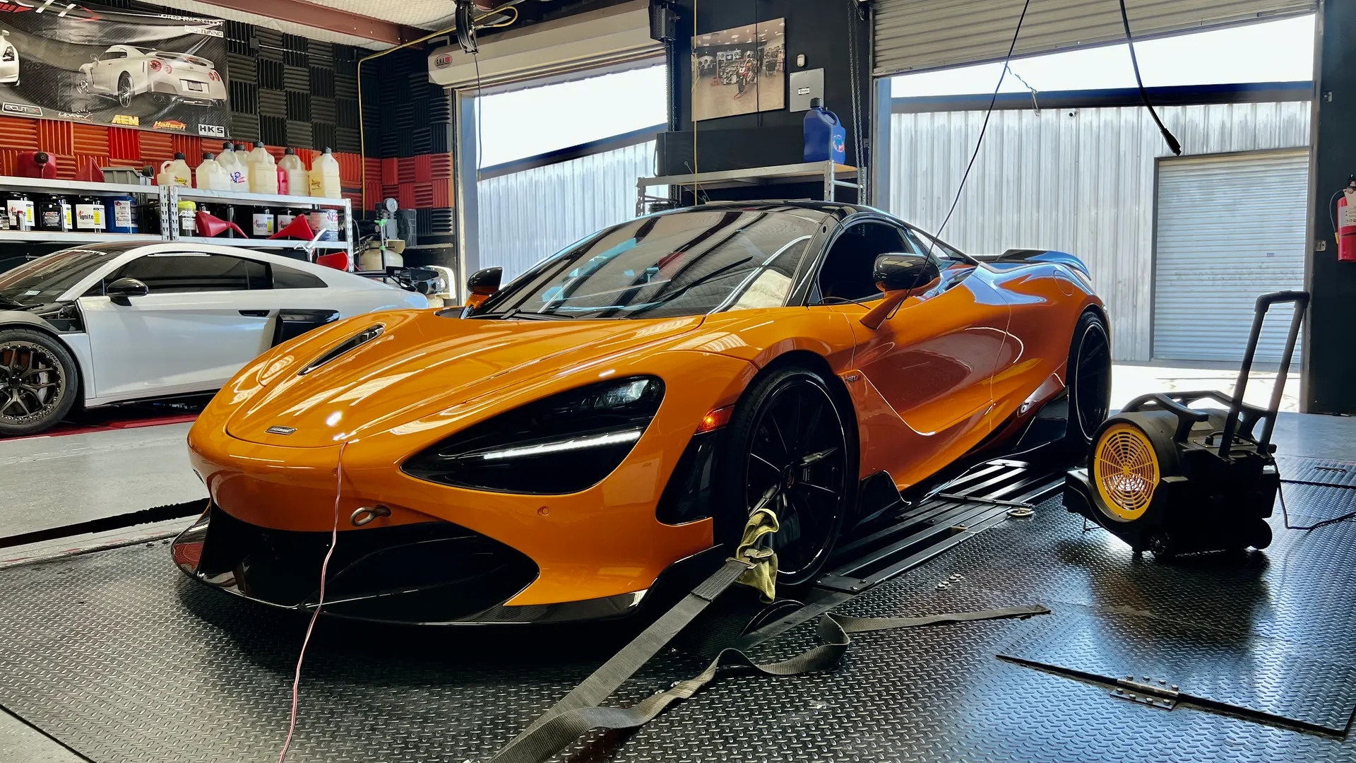 Orange McLaren 720S strapped to a dynamometer for performance tuning at Jotech Motorsports.