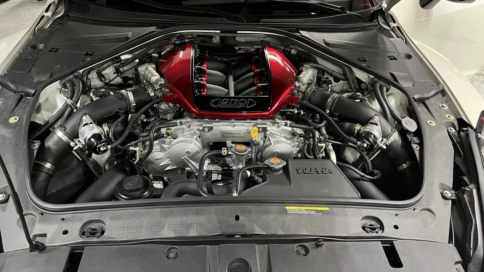 Detailed view of a Jotech-tuned Nissan GT-R engine bay featuring a custom red intake manifold and performance induction system.