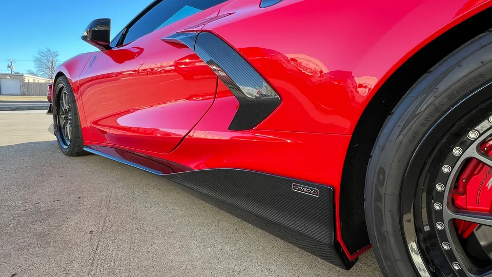 Red Corvette C8 with carbon fiber side skirts and side air intake vents, showcasing Jotech Motorsports branding.