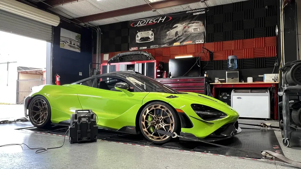 A lime green McLaren 720S strapped to a dynamometer at Jotech Motorsports for performance tuning.