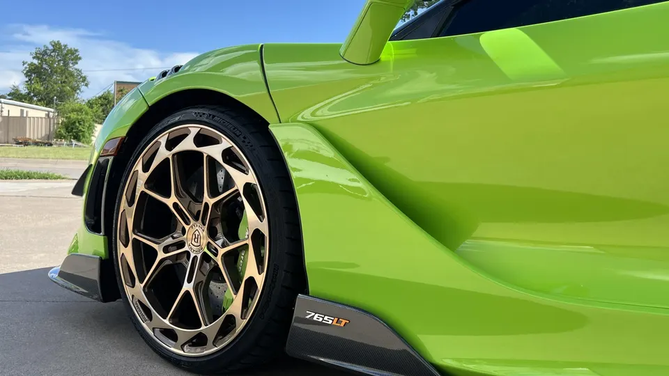 A lime green McLaren 765LT with custom bronze forged wheels and carbon fiber aero elements, showcasing the side profile.