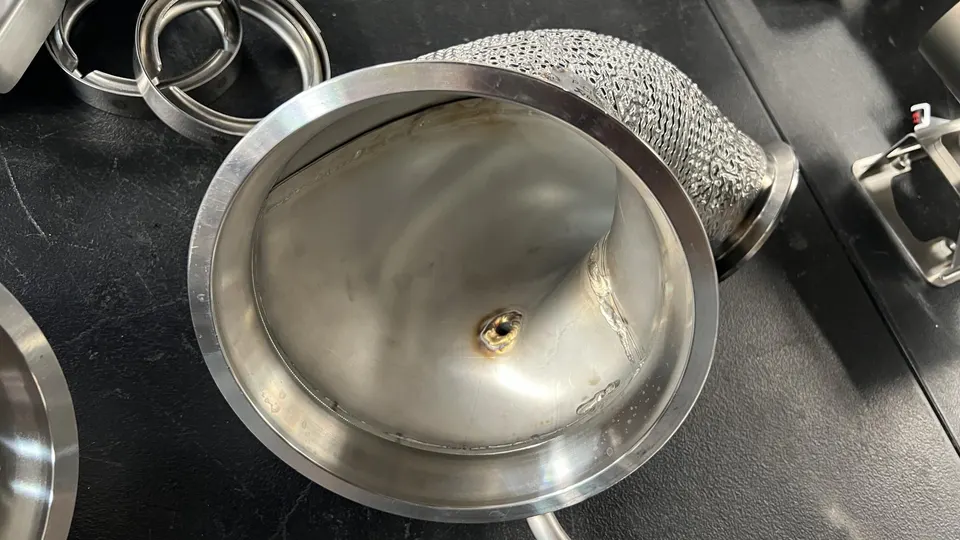 Close-up of a stainless steel exhaust component with an O2 sensor bung, likely a downpipe or test pipe.