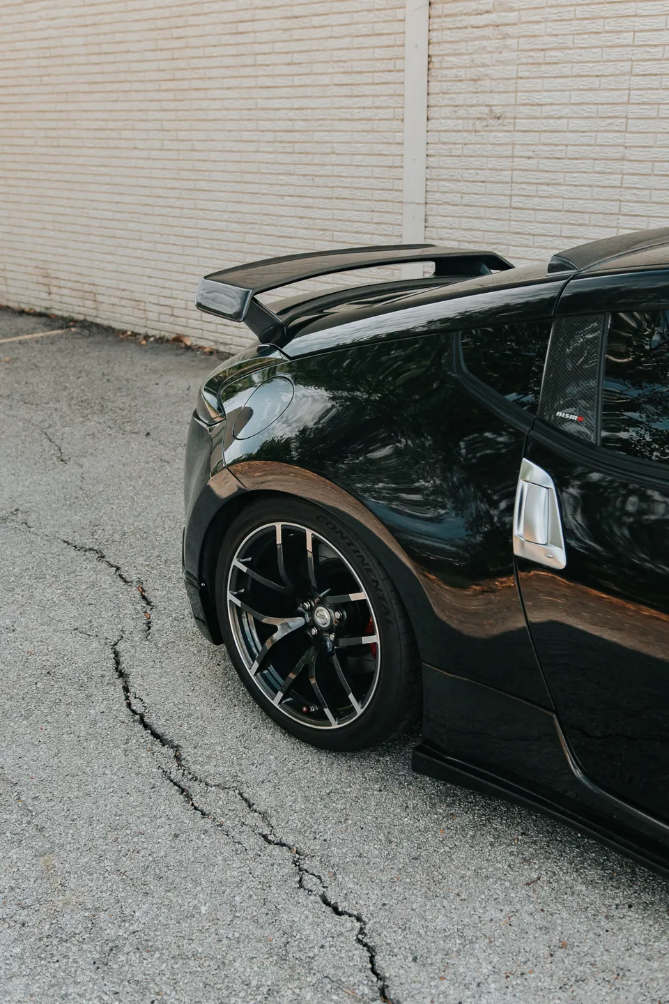 Close-up of a black Nissan 370Z Nismo featuring a prominent rear wing and performance wheels.