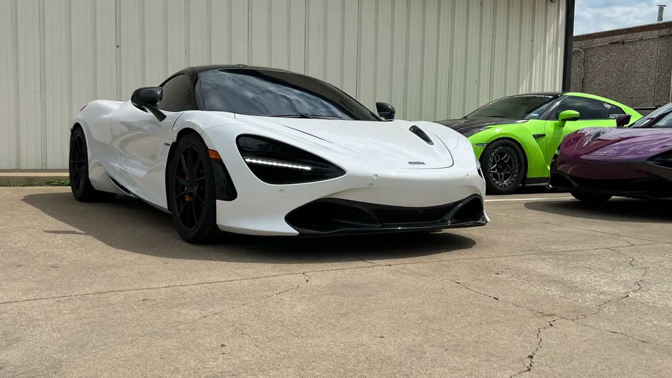 White McLaren 720S parked with a green Nissan GT-R and a purple supercar outside Jotech Motorsports.
