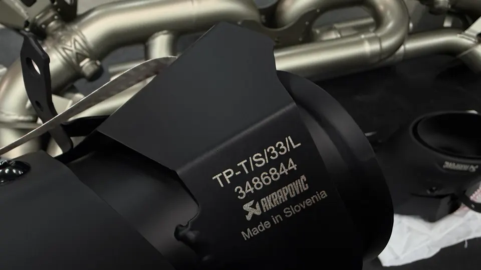 Close-up of an Akrapovic exhaust component with part number TP-T/S/33/L 3486844, made in Slovenia.
