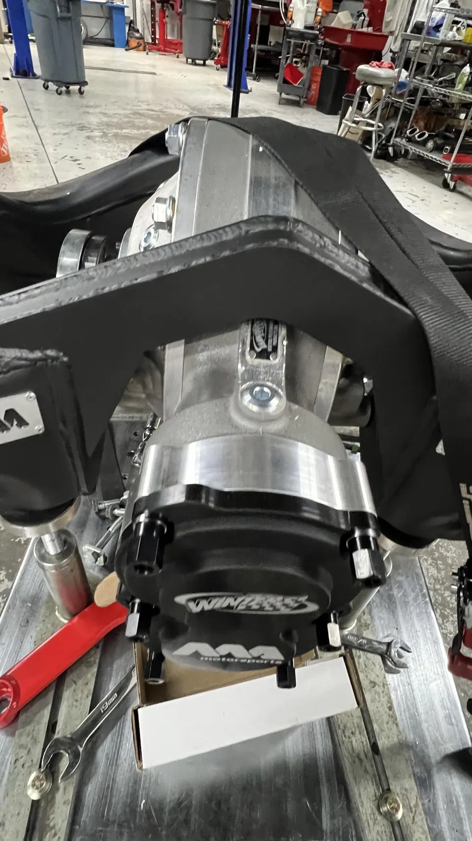 A close-up of a Winless Motorsports differential assembly being worked on in a performance shop.