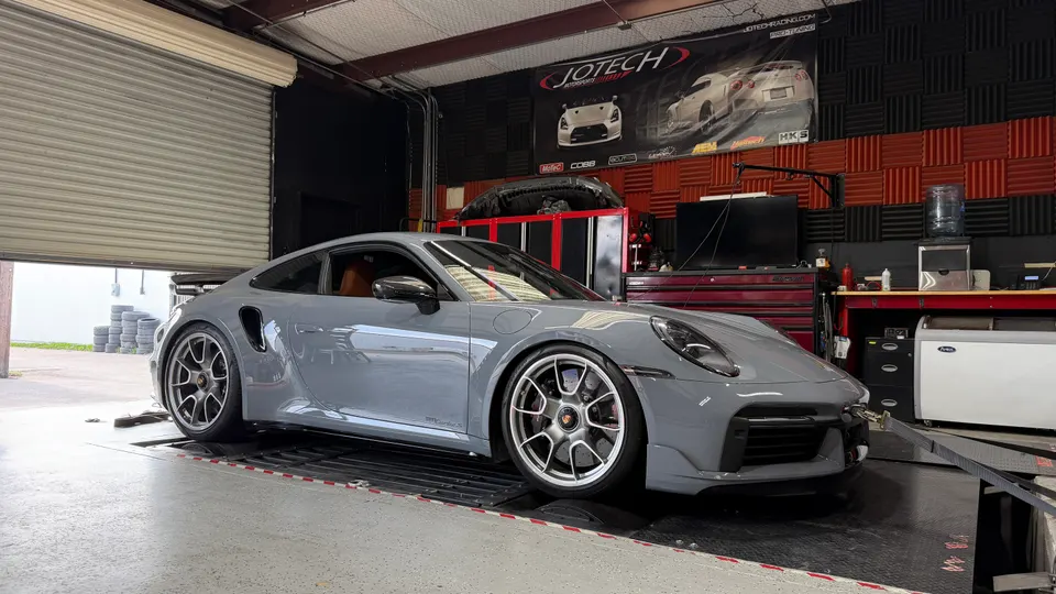 Grey Porsche 911 Turbo S strapped to a dynamometer at Jotech Motorsports for performance tuning.