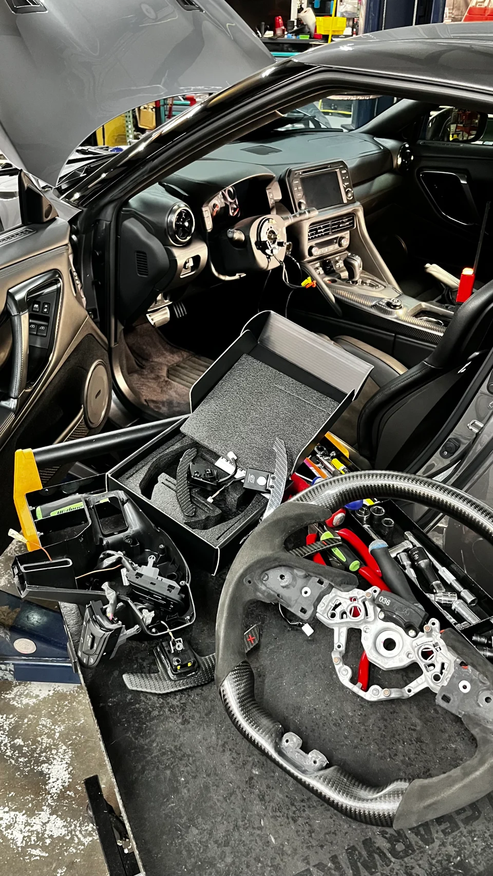 The new MAGNETIC CARBON FIBER PADDLE SHIFTERS are being installed on your steering wheel.