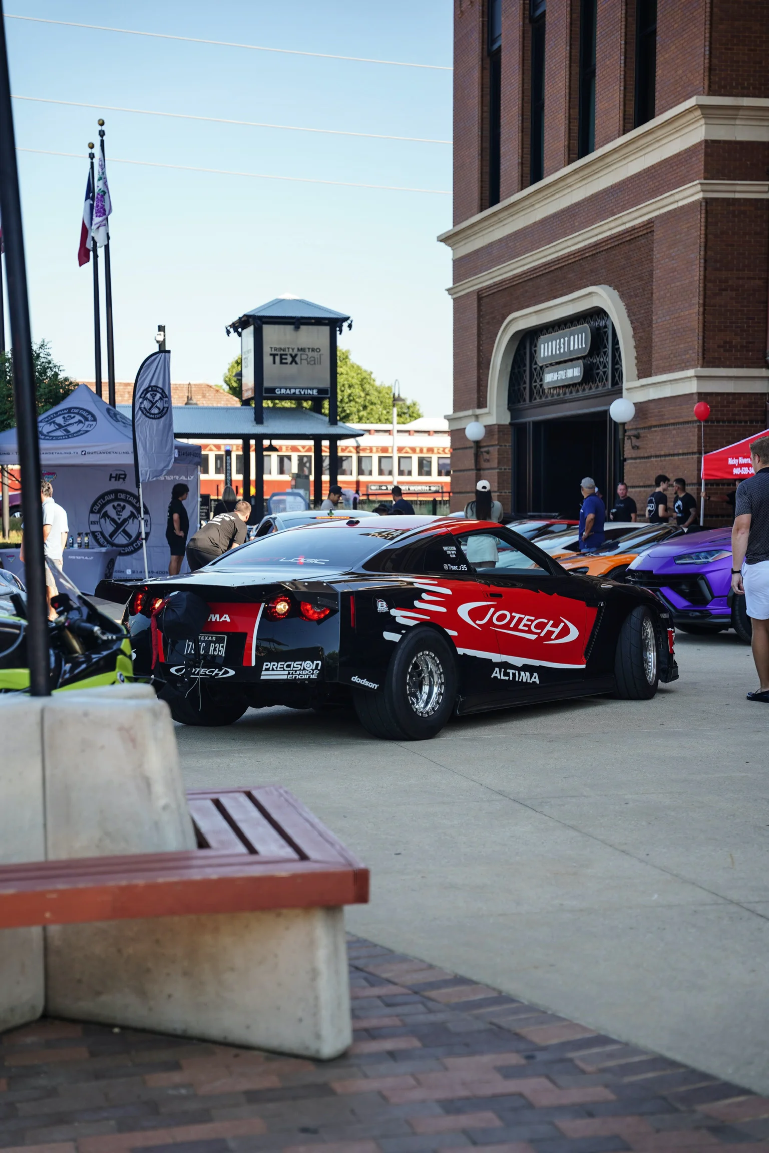 A black and red Jotech Motorsports Nissan GT-R drag car with widebody kit and drag wheels parked at an outdoor car event.